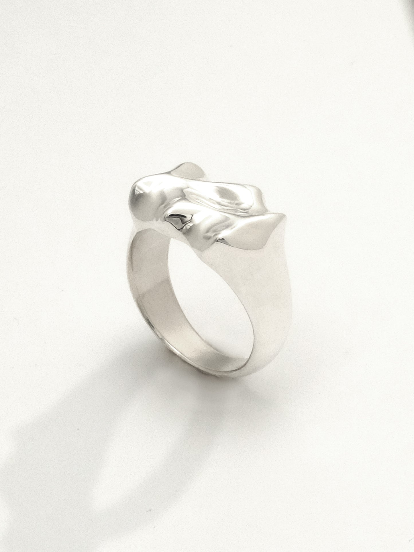 Close-up of a sterling silver ring featuring a liquid-like texture design with a mirror shine finish. The ring is 12mm wide at its widest point.