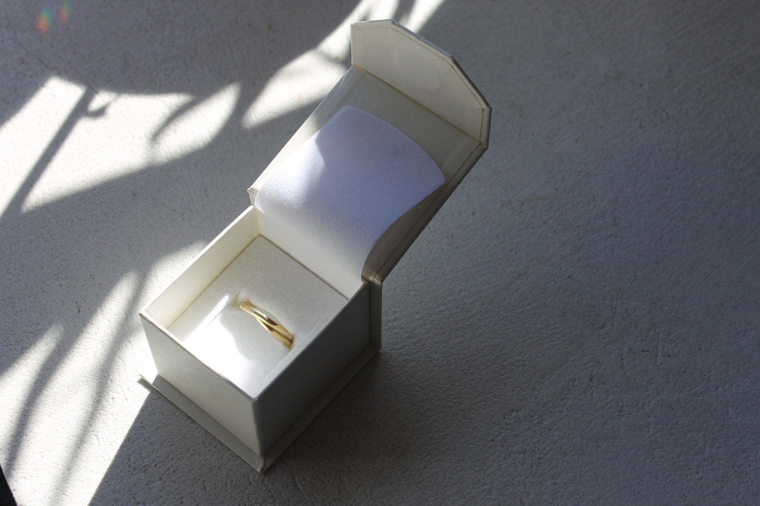 close up of gold Entwined ring in the elegant box provided with purchase, depicting the ring is taken care of when not being worn and conveying the high end value the box adds. 